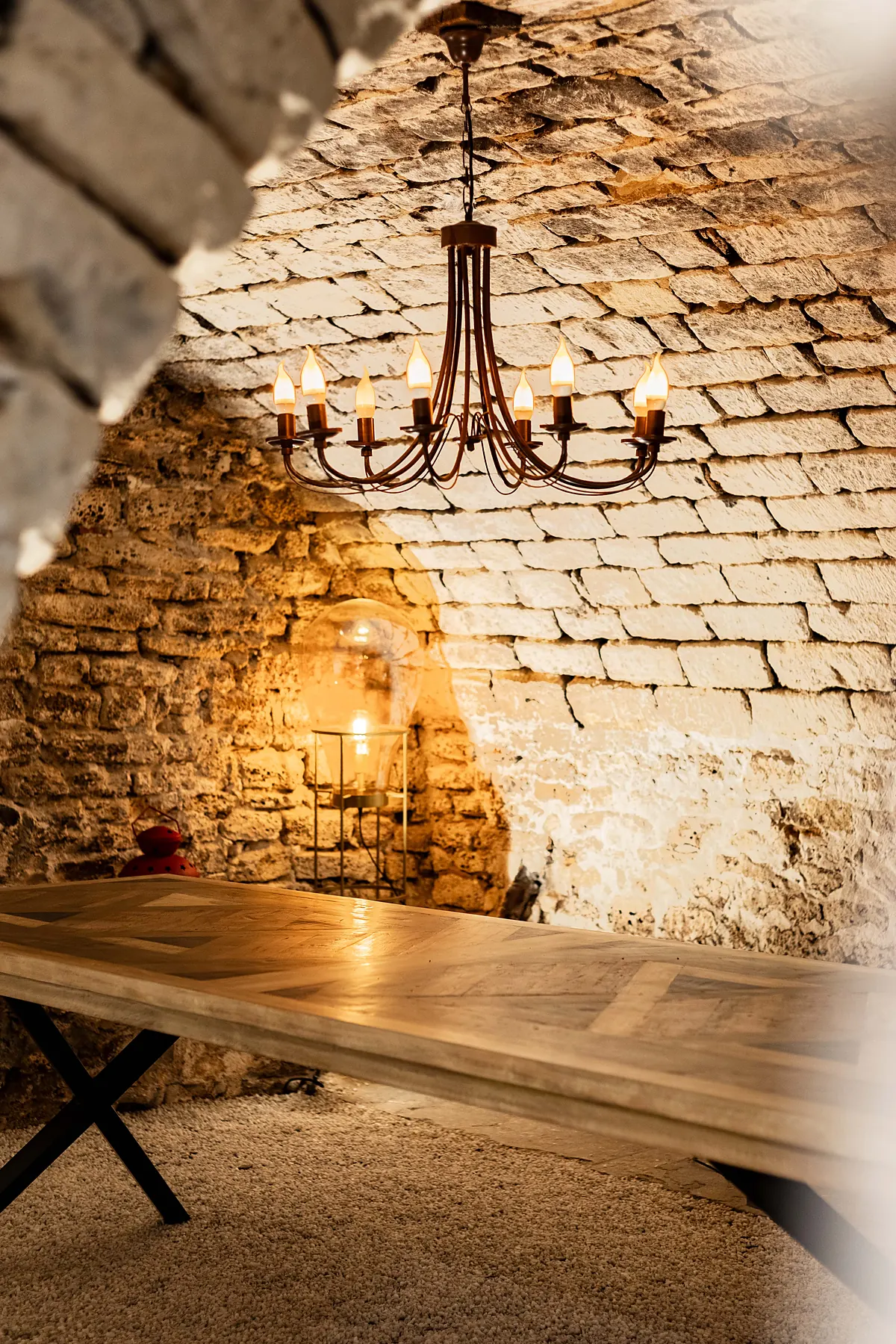 La cave voûtée en pierre et son lustre