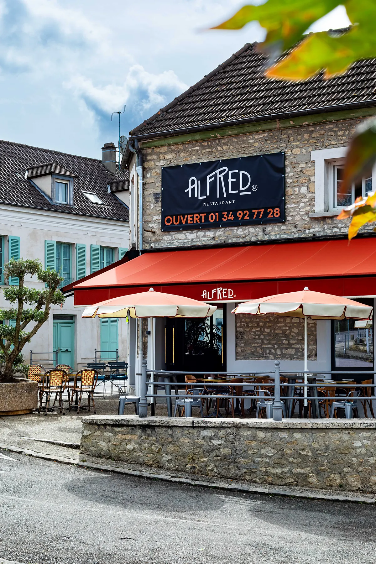 La façade d'Alfred et sa terrasse sous l'auvent rouge